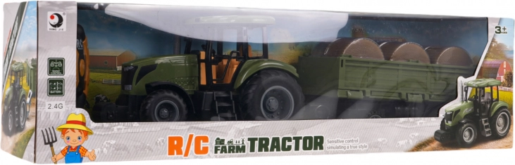 Zielony zdalnie sterowany traktor z przyczepą