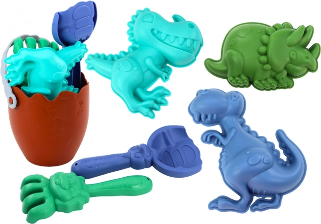Zestaw do piasku dinozaury z wiaderkiem w kształcie jaja, łopatką, grabiami i foremkami