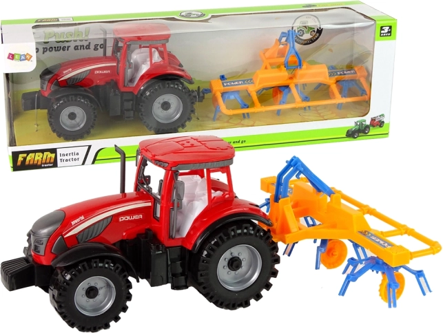 Czerwony traktor z przetrząsaczem z napędem ciernym