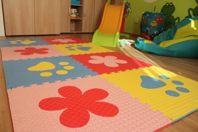 Piankowy dziecięcy dywan z niebieskimi i żółtymi łapkami