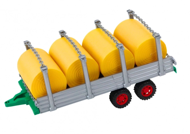 Duży traktor z przyczepą i belami siana