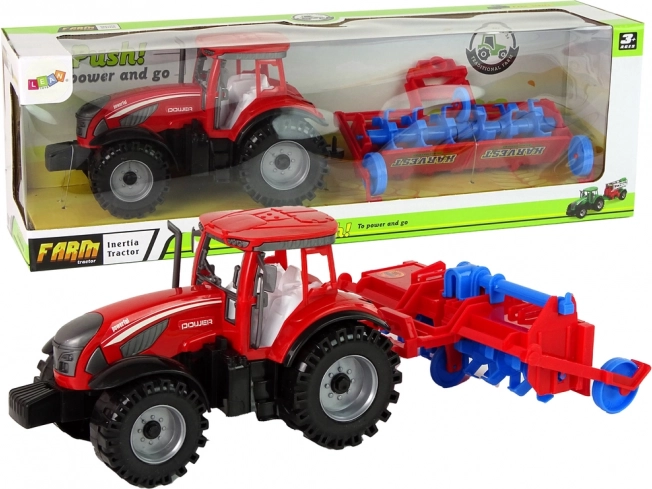 Czerwony traktor z pługiem z napędem ciernym