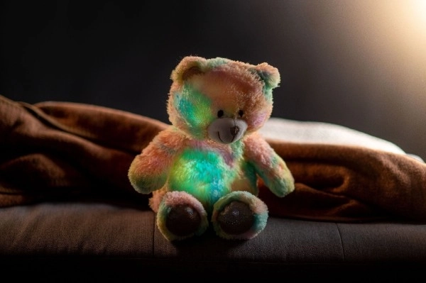 Senny miś tęczowy pluszowy 40cm na baterie ze światłem i dźwiękiem w woreczku