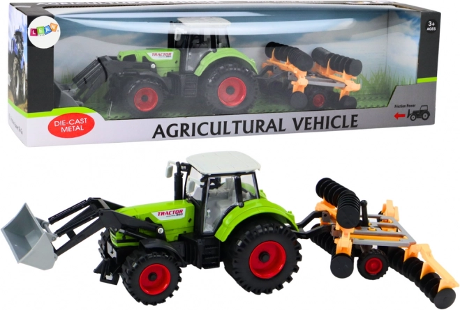 Traktor z broną talerzową i ładowaczem czołowym zielony