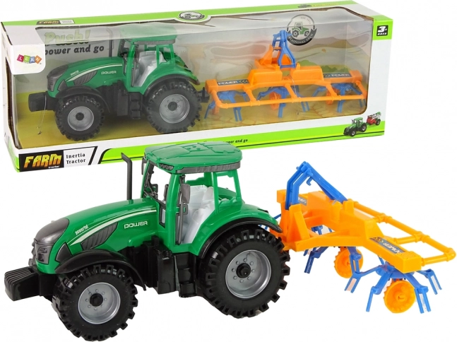 Zielony traktor z grabicą z napędem ciernym