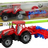 Czerwony traktor z pługiem z napędem ciernym